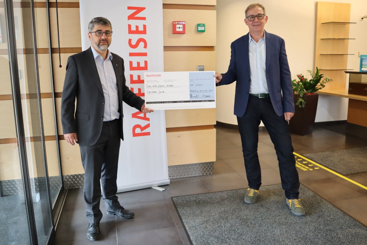 Remise du chèque à Caritas Jura