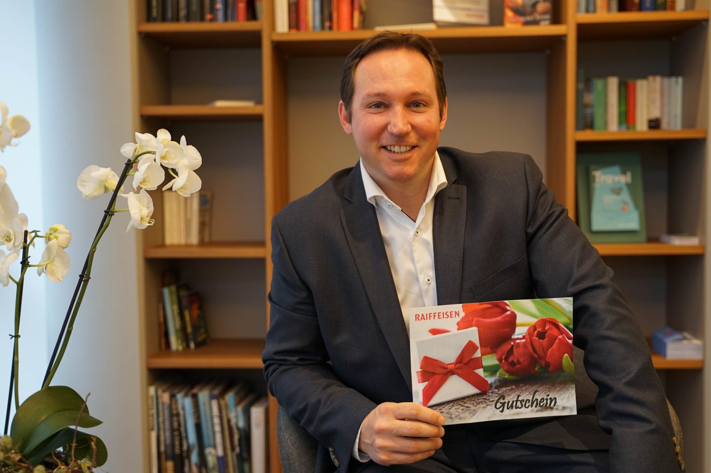 Kevin Rohner präsentiert den Gutschein im Wert von 25 Franken. 