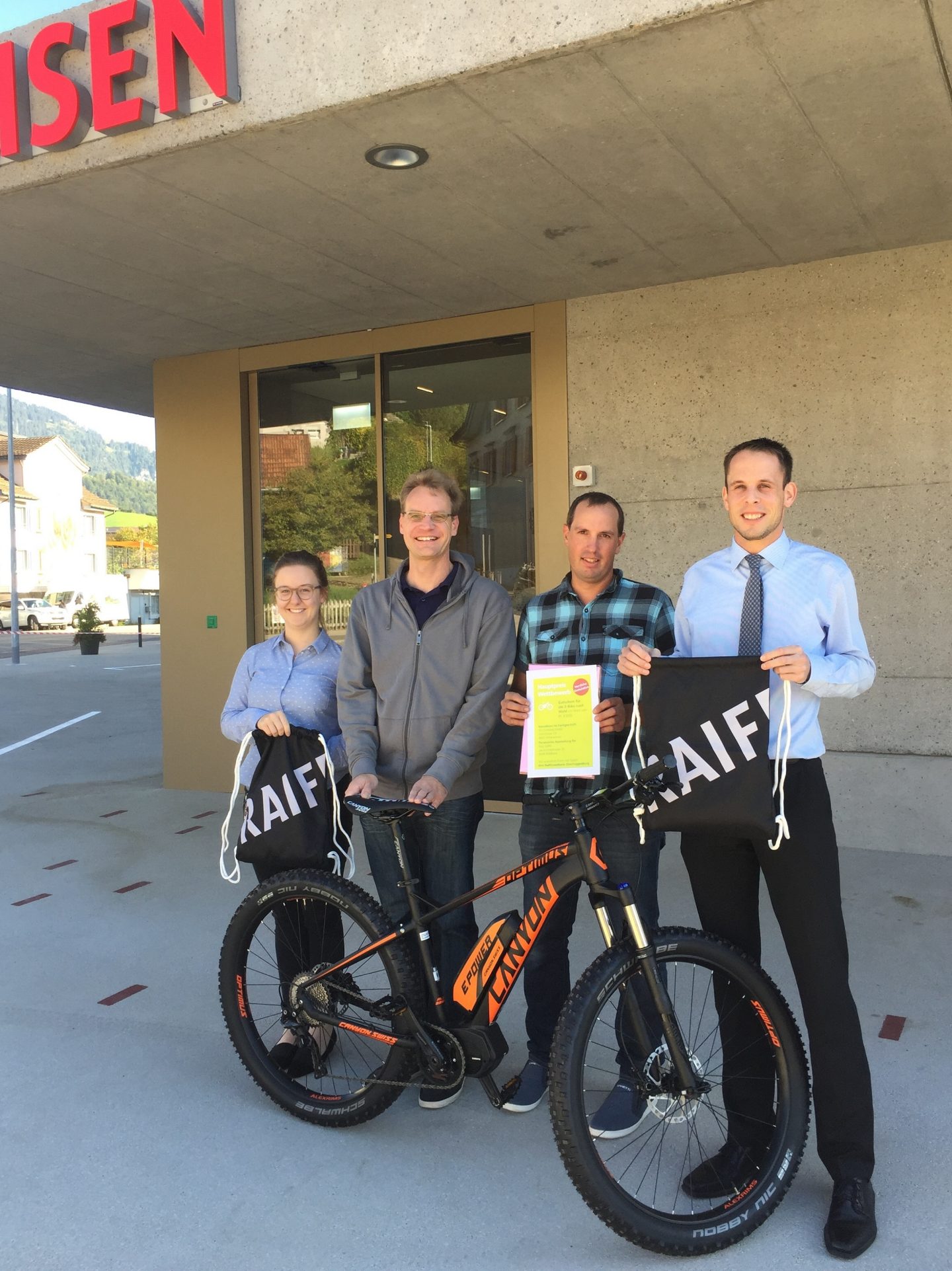 Thomas Bleiker und Elena Kuriger übergeben die Gutscheine den beiden Gewinnern.