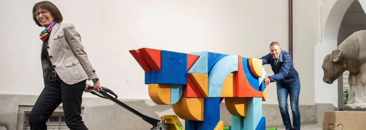 Rita Roos schiebt symbolisch die ChääsWelt-Kuh zu Raiffeisen