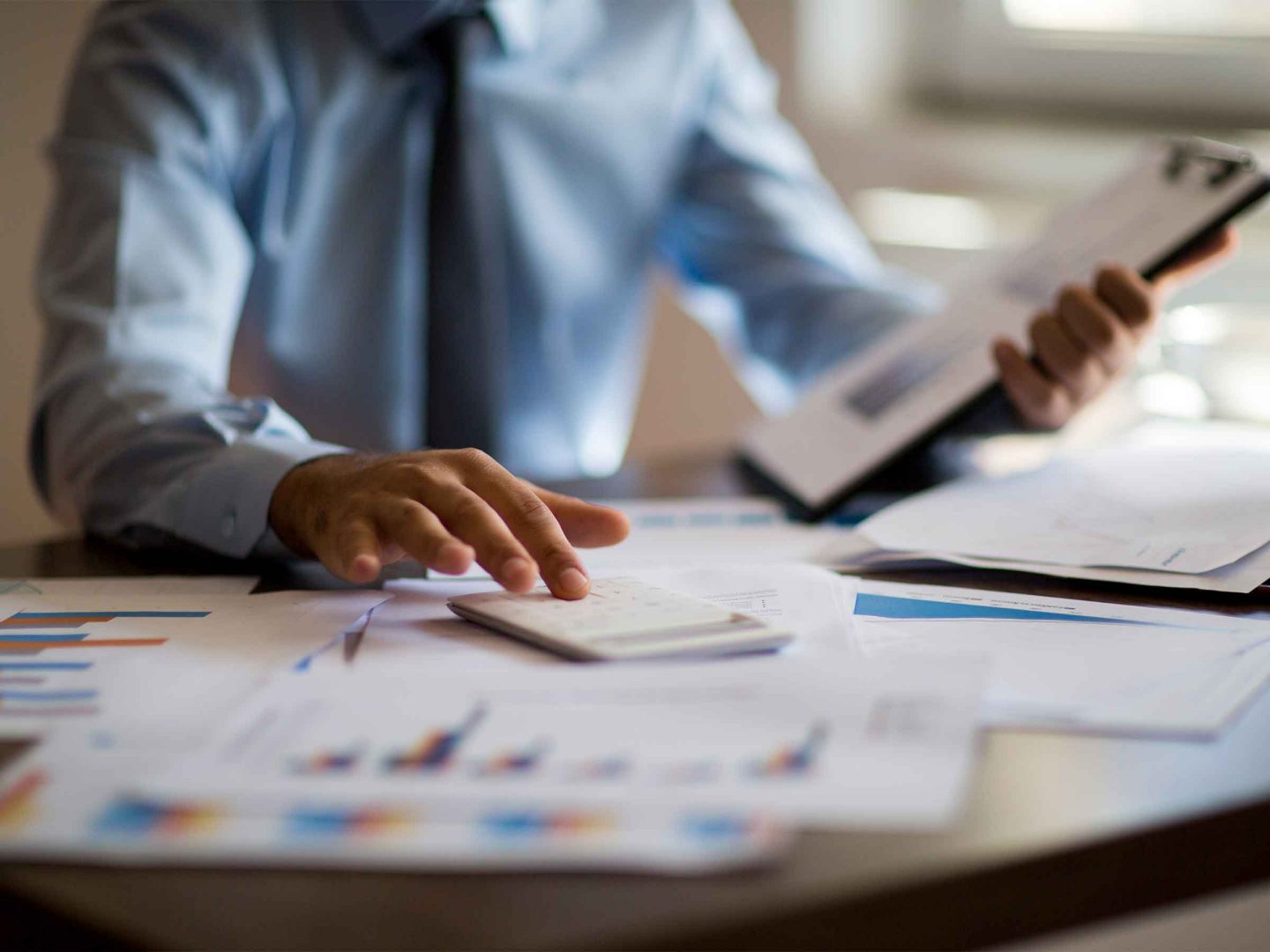 Homme d’affaires avec une calculatrice dans son bureau