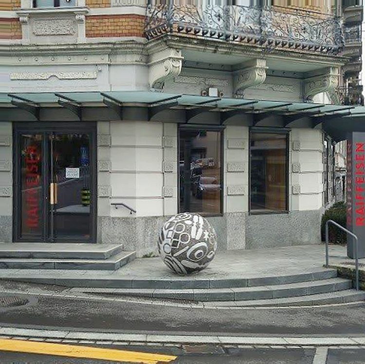 La boule en mosaïque devant l'entrée de la banque