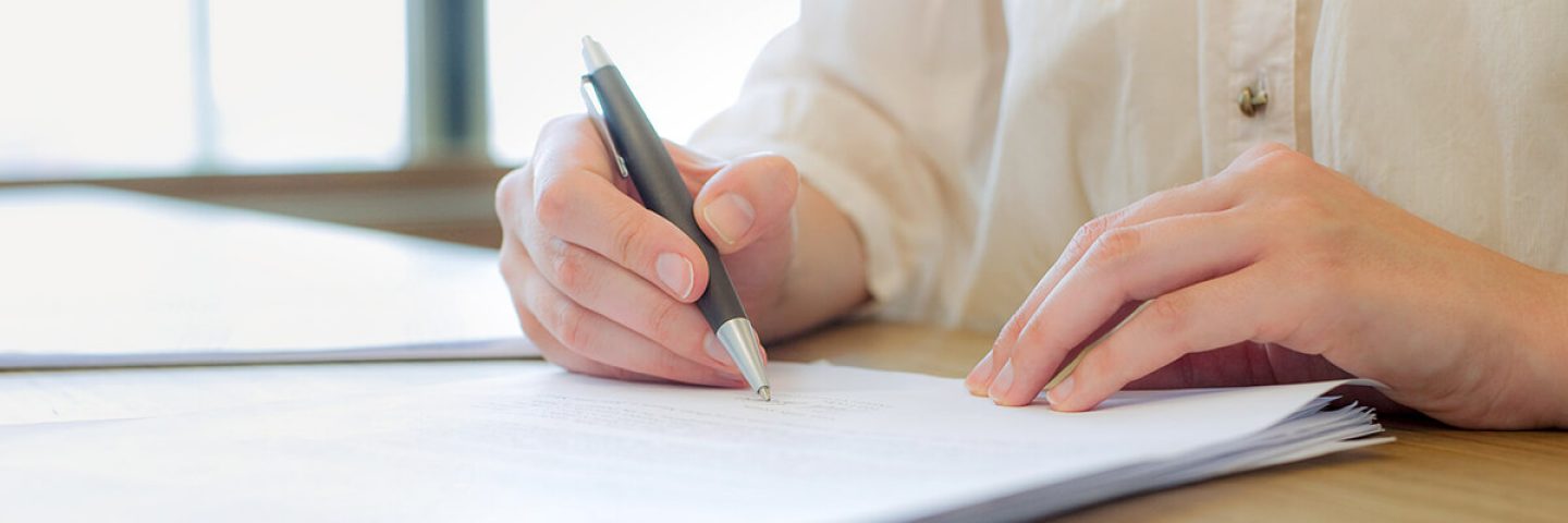 Mann unterschreibt auf Unterlagen