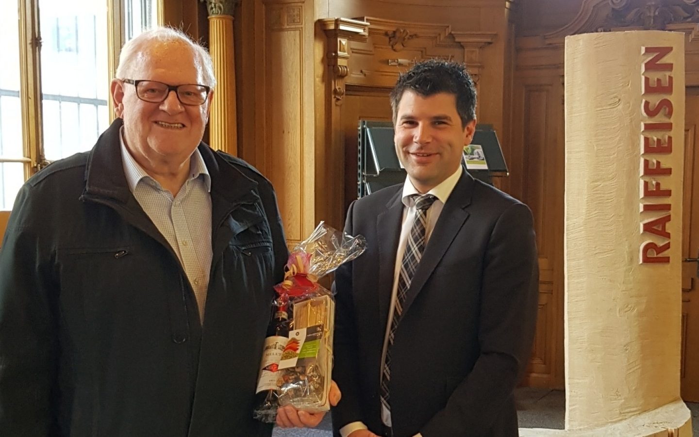Der Gewinner, Josef Gasser, nimmt den Preis von Mario Bianchi, Vermögensberater, entgegen.