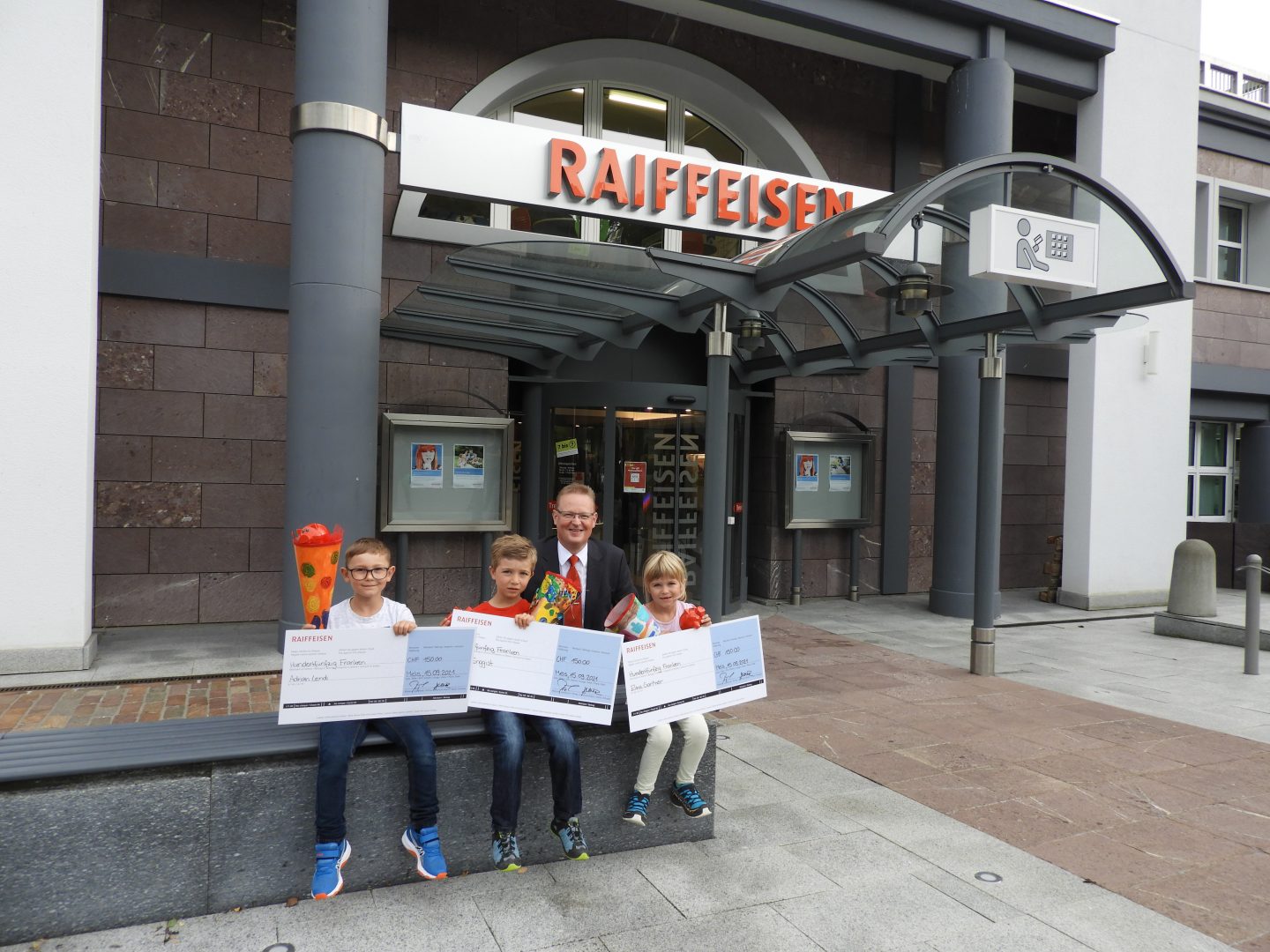 Elina Gantner (Flums), Adrian Lendi (Mols) und Nicolas Enggist (Sargans) mit Josef Zemp (Mitglied der Bankleitung).