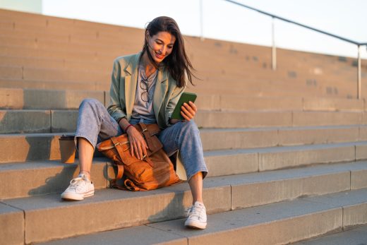 Frau mit Smartphone auf einer Treppe